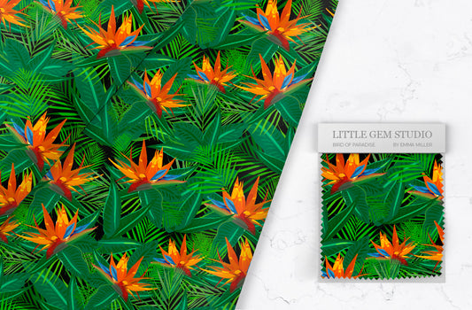 Bird of paradise fabric by Emma laid out on a white marble worktop with her logo to the left